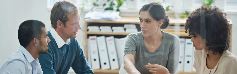 School principal speaking with teachers during a meeting