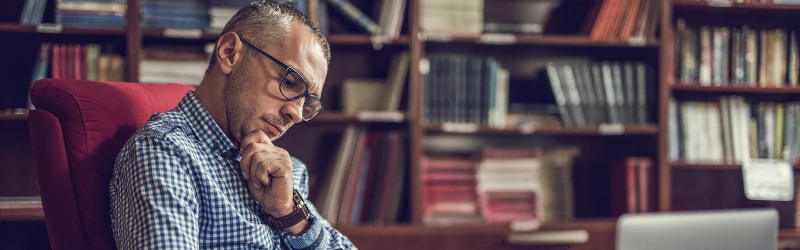 College dean reviewing papers at his desk